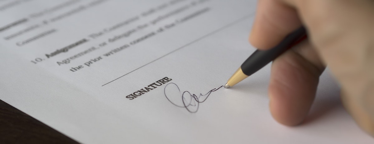 A man signing a title insurance document.